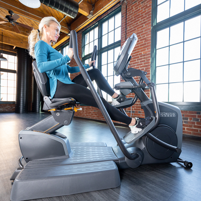 Woman using recumbent elliptical - arm and leg movement