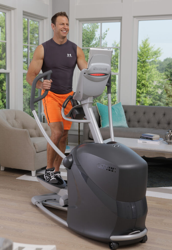 Man working out at home using the Q37xi standing elliptical
