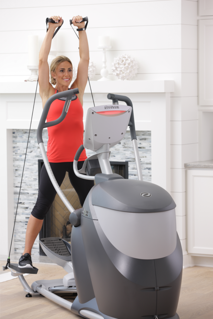 Woman using the CROSS CIRCUIT+ Kit while working out on the Q47x standing elliptical