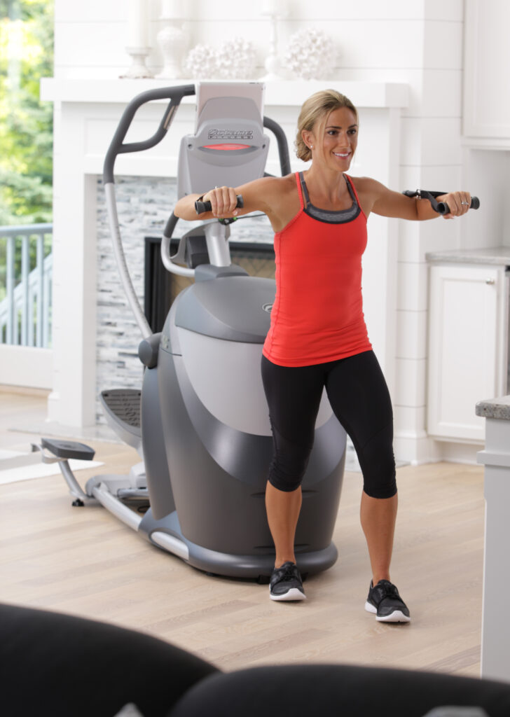 Woman using the CROSS CIRCUIT+ Kit while working out on the Q47xi standing elliptical